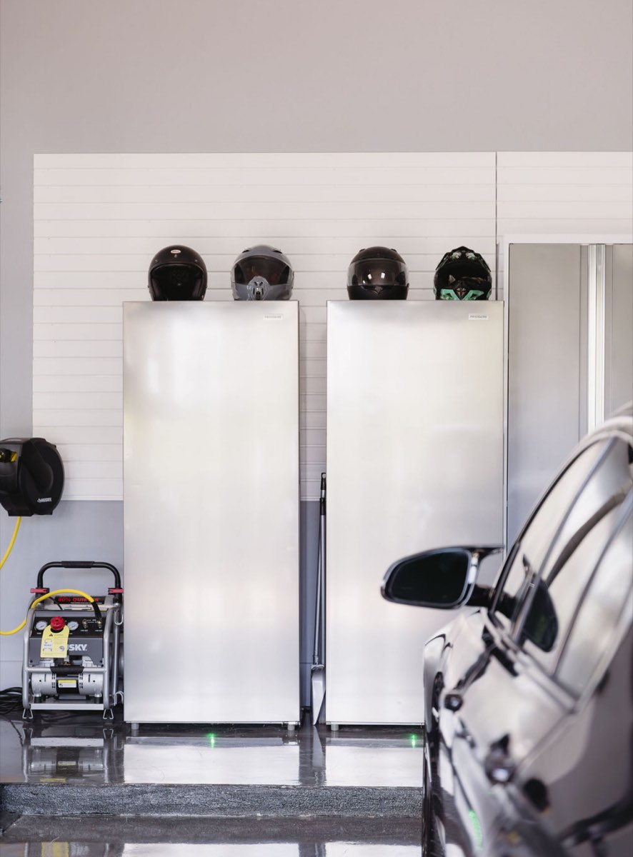 Tall metal garage cabinets installed against a slatwall